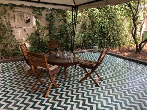 un patio con 2 sillas, una mesa y una sombrilla en Youth Hostel International Fez, en Fez