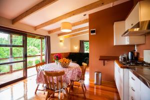 a kitchen and dining room with a table and chairs at Relax a Lodge in Kerikeri