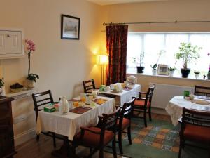 a dining room with two tables and chairs and a window at Oxfordbnb in Oxford