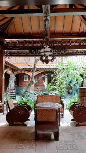 un patio con sillas, una mesa y una lámpara de araña en Omah Wetan Homestay, en Malang