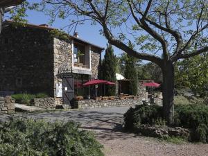 a building with red umbrellas outside of it at La Palombe in Octon