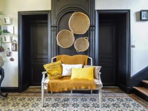 - une chaise avec des oreillers jaunes dans l'établissement La Paresse en Ville, à Bayeux