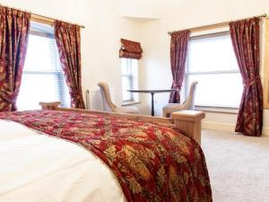 a bedroom with a bed and a table and windows at Parkers House Bed & Breakfast in Newtown +4 photos