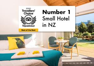 een slaapkamer met een groot bed en een klein hotel in nz bij Abel Tasman Lodge in Marahau