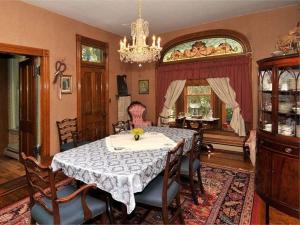 uma sala de jantar com uma mesa e um lustre em Victorian Loft Bed and Breakfast em Clearfield
