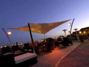 a rooftop patio with tables and chairs and lights at Pebble Beach Seaview Restaurant & Rooms in Milton