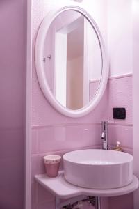 La salle de bains est pourvue d'un lavabo blanc et d'un miroir. dans l'établissement Mirò B&B, à Acquaviva delle Fonti