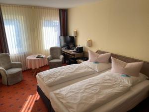 ein Hotelzimmer mit 2 Betten und einem Schreibtisch in der Unterkunft Hotel Restaurant Ennen in Norderney