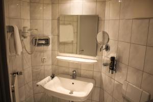 a bathroom with a sink and a mirror at Hotel zur Altstadt in Freudenberg +12 photos