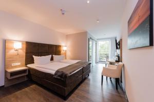 1 dormitorio con 1 cama, 1 mesa y 1 silla en WH Hotels Papenburg Zentrum, en Papenburg