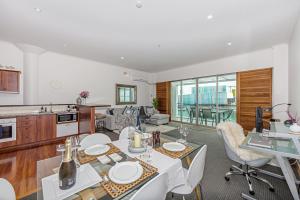 a kitchen and living room with a table and chairs at Princes Wharf - Absolute Waterfront & Great Views in Auckland