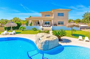 een villa met een zwembad en een huis bij Finca Torrat in Muro