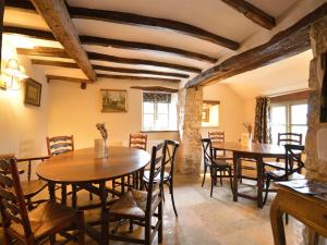 een eetkamer met houten tafels en stoelen bij The Plough Inn in Cheltenham