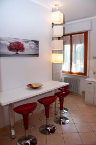 a kitchen with a white counter and red bar stools at A casa di Debby alloggio comodo e accogliente in Foligno