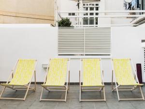 3 Stühle und ein Tisch auf einer Terrasse in der Unterkunft Flat El Porto - families only, no groups in Valencia