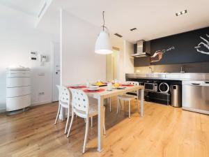 Un comedor con una mesa y sillas en una cocina. en Flat El Porto - families only, no groups, en Valencia