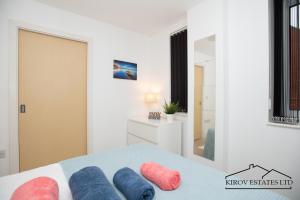 a bedroom with a bed with blue and pink pillows on it at Poseidon Apartment - 1 Bed Flat - Heart of Town in Southampton