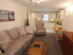 uma sala de estar com um sofá, uma mesa e uma cozinha em The Post House em Kinsale