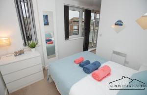 a bedroom with a bed with blue and red pillows on it at Poseidon Apartment - 1 Bed Flat - Heart of Town in Southampton