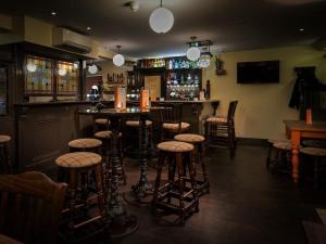 a bar with bar stools in a room at The Porterhouse in Willingham