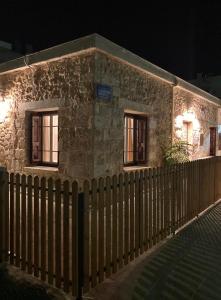 a stone building with a fence in front of it at Reina House in Chania