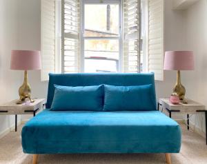a blue couch in a room with two lamps at Price & Weeks - Heart of Bath in Bath