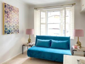 a blue couch in a living room with two lamps at Price & Weeks - Heart of Bath in Bath