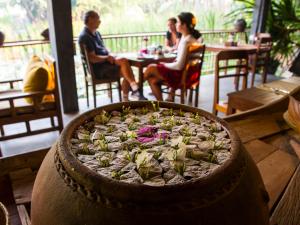 a pizza in a pot on a table in a restaurant at Maisons Wat Kor in Battambang