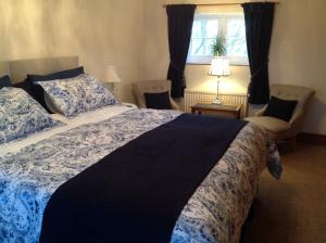 Un dormitorio con una cama grande y una ventana en Primrose Cottage, en Norwich