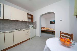 a kitchen with a bowl of fruit on a table at Adria Brela Apartments in Brela