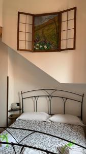 a bedroom with a bed with a painting on the wall at BORGHETTO AIRPORT/HOSPITAL in Bergamo