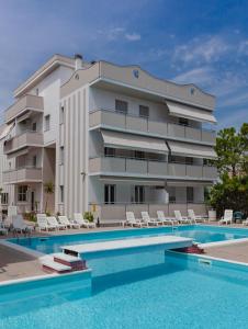 un hotel con piscina di fronte a un edificio di Holiday Club Residence ad Alba Adriatica