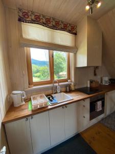 una pequeña cocina con fregadero y ventana en Apartament Babia Góra, en Zawoja