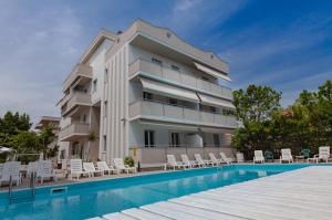 an apartment building with a swimming pool and chairs at Holiday Club Residence in Alba Adriatica