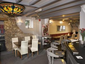 a restaurant with tables and chairs and a stone wall at The Queens Head in Oxford