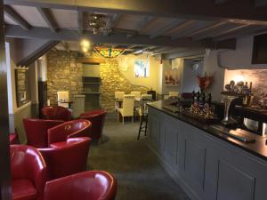 a bar in a restaurant with red chairs at The Queens Head in Oxford