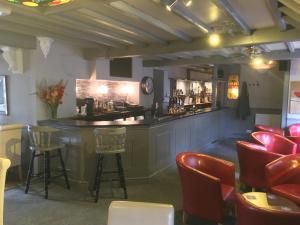 un bar in un ristorante con sedie rosse di The Queens Head a Oxford
