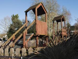 un parco giochi in un parco con recinto in legno di The Queens Head a Oxford