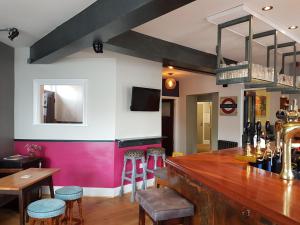 a bar with a wooden counter and stools at The Railway in Skipton