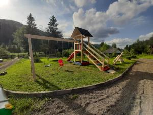 a playground with a slide in the grass at Pensiunea Andrade in Putnişoara