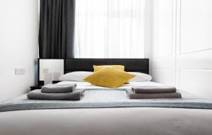 Un dormitorio con una cama grande con almohadas amarillas. en Central Hoxton Shoreditch, en Londres