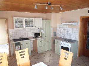 a kitchen with white cabinets and a stove top oven at Lehnenhof in Dargun