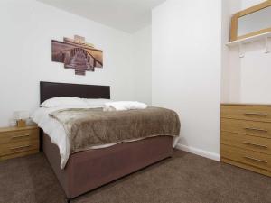 a bedroom with a bed and a dresser with a picture on the wall at Park house in Leeds