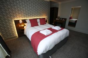 ein Hotelzimmer mit einem großen Bett mit Handtüchern darauf in der Unterkunft The Queens Head Hotel in Rothbury