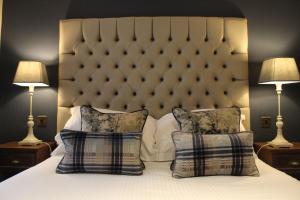 a bedroom with a bed with two pillows and two lamps at Red Dragon Inn in Kirkby Lonsdale