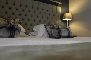 una camera da letto con un grande letto con cuscini sopra di Red Dragon Inn a Kirkby Lonsdale
