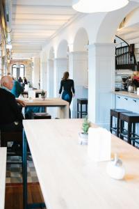 un grupo de personas sentadas en mesas en un restaurante en OX Hotel Altes Spital, en Müllheim