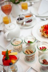 a white table topped with dishes of food and drinks at Hotel Kaiserhof Wien in Vienna
