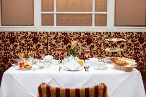 a table with a white table cloth and food on it at Hotel Kaiserhof Wien in Vienna