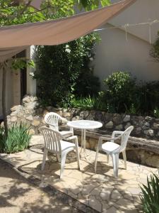 a patio with a table and two chairs and a table at Résidence les Mûriers in Allegre Les Fumades